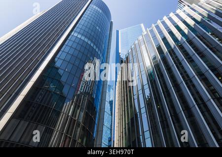 Flacher Blick auf moderne Glashochhäuser vor blauem Himmel Stockfoto