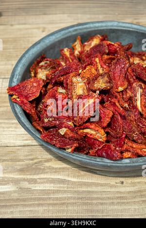 Sonnengetrocknete Tomaten und traditioneller Tomatentrocknungsprozess, frische reife Tomaten, die zum natürlichen Trocknen unter der Sonne angeordnet sind Stockfoto