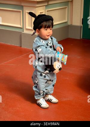 Ein Kind im Pyjama Mickey Maus im Tokyo Disneyland in Urayasu, Chiba, Japan Stockfoto