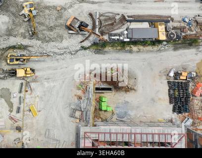 Aus der Vogelperspektive einer geschäftigen Baustelle mit Baggern, Bewehrungspfählen und Baumaterialien in Sariyer, Istanbul, Turkiye. Stockfoto