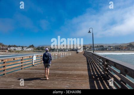 Frau, die auf dem Cayucos Pier am Cayucos Beach in Zentralkalifornien läuft; USA Stockfoto