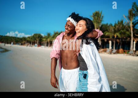 Reines Glück. Ein junges, vielseitiges, multiethnisches Paar genießt jeden Moment ihres tropischen Urlaubs Stockfoto
