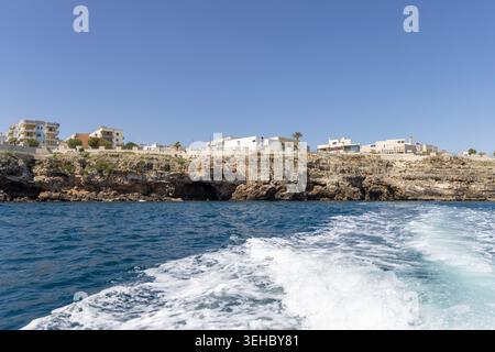 Polignano a Mare, Italien, Apulien - 24. Mai 2024: Blick vom Wasser aus auf die malerische Küste mit Klippen und Höhlen an der Adria. Bootstour entlang der Stockfoto