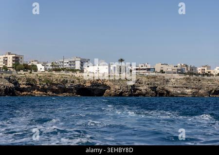 Polignano a Mare, Italien, Apulien - 24. Mai 2024: Blick vom Wasser aus auf die malerische Küste mit Klippen und Höhlen an der Adria. Bootstour entlang der Stockfoto