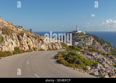 Gewundene Straße, die zum Leuchtturm Far de Formentor an der Nordspitze Mallorcas führt, umgeben von felsigen Klippen, Blick auf das Mittelmeer und hell klar Stockfoto