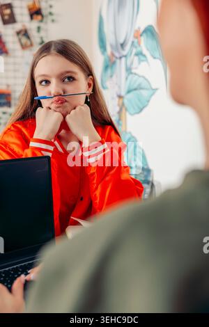Mutter und Tochter sitzen an einem Café-Tisch und genießen Kaffee. Die Mutter hat rote Haare und trägt einen grünen Pullover. Die Tochter hat lange braune Haare und Stockfoto