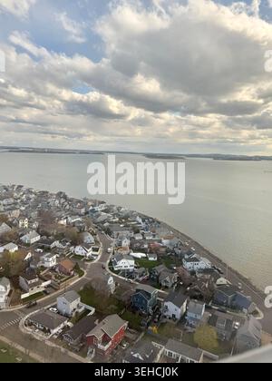 Luftaufnahme des Coughin Park und Boston Harbor von einem Flugzeugfenster mit einem dramatischen Himmel und weißen Wolken während der Landung in Boston Logan Stockfoto