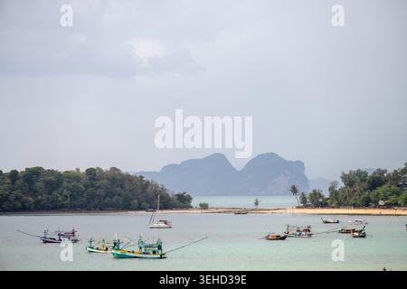 Fischerboote ruhen in der Nähe einer Sandküste und tropischen Inseln am Klong Muang Beach Krabi Thailand. Stockfoto