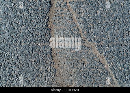 Blick von oben auf beschädigte Asphaltbeläge mit vertikaler Rissstruktur Stockfoto