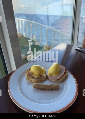 Frühstück lächelnde Eier Benedict auf dem Kreuzfahrtschiff mit Meerblick Stockfoto