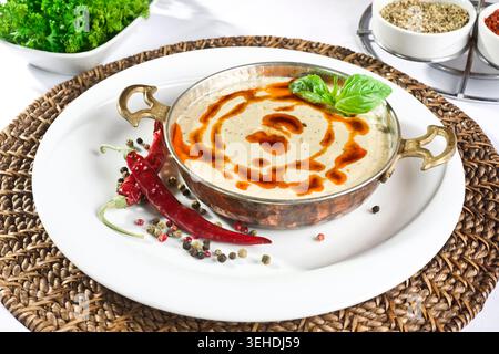 Traditioneller Hummus auf einem Teller serviert, cremiger Kichererbsen-Dip mit Tahini, Olivenöl und Gewürzen, mediterraner und türkischer Meze Stockfoto