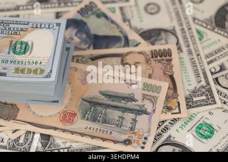 Japanische Yen-Banknoten und ein Stapel US-Dollar im globalen Finanzkonzept für den Devisenwechsel Stockfoto