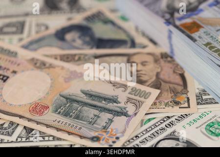 Japanische Yen-Banknoten und ein Stapel US-Dollar im globalen Finanzkonzept für den Devisenwechsel Stockfoto