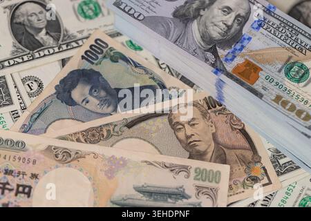 Japanische Yen-Banknoten und ein Stapel US-Dollar im globalen Finanzkonzept für den Devisenwechsel Stockfoto