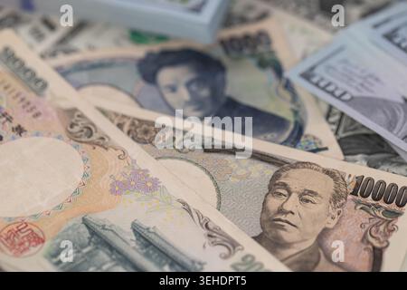 Japanische Yen-Banknoten und ein Stapel US-Dollar im globalen Finanzkonzept für den Devisenwechsel Stockfoto