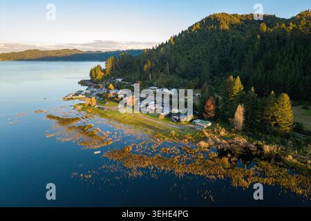 Lake Rotoma, ein kleines Dorf am gleichnamigen See in der Gegend von Rotorua, Neuseeland. Blick aus der Vogelperspektive bei Sonnenuntergang Stockfoto