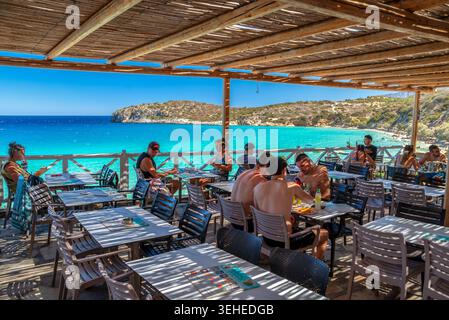 Strand von Voulisma, Griechenland - 2. September 2025: Touristen speisen während eines sonnigen Sommerurlaubs auf der Terrasse des Restaurants am Meer mit Panoramablick auf das türkisfarbene Meer Stockfoto