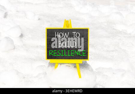 So erstellen Sie ein Resilienzsymbol. Konzeptworte wie man Widerstandsfähigkeit auf schönen Tafeln schafft. Schöner weißer Schnee Hintergrund. Business wie man baut Stockfoto