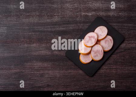Gekochte Hähnchenwurst für Sandwiches und Antipasto zum Abendessen. Wurstscheiben als Lebensmittelhintergrund für Ihr Design Stockfoto