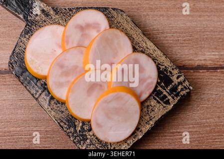Gekochte Hähnchenwurst für Sandwiches und Antipasto zum Abendessen. Wurstscheiben als Lebensmittelhintergrund für Ihr Design Stockfoto