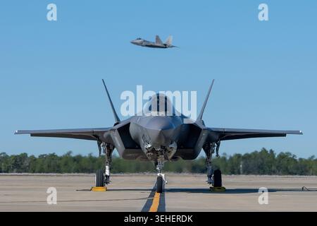 Eine F-35A Lightning II, die der 58th Fighter Squadron zugeteilt wurde, wartet auf die Erlaubnis, als ein F-22 Raptor, der der 27th Fighter Squadron zugeteilt wurde, zu fahren Stockfoto