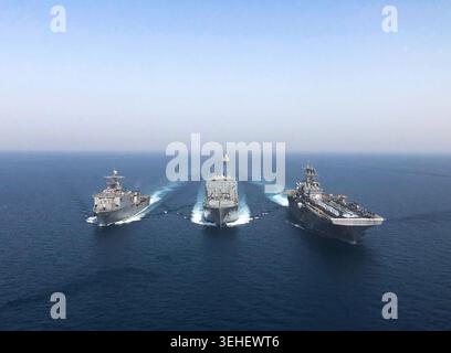 ARABIAN GULF (25. April 2020) – das Dock-Landungsschiff USS Oak Hill (LSD 51), ein Trockenfracht- und Munitionsschiff, und begleitend Stockfoto