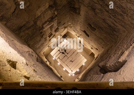 Grabkammer tiefer Schacht in der Pyramide von Djoser (Stufenpyramide von Djoser) in Sakkara Nekropolis, Ägypten mit beleuchtetem Sarkophag. Stockfoto