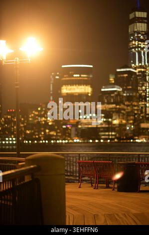 Stadtlichter Leuchten. Straßenlaternen und Hochhausfenster erleuchten die abendliche Stadtszene New york Stockfoto
