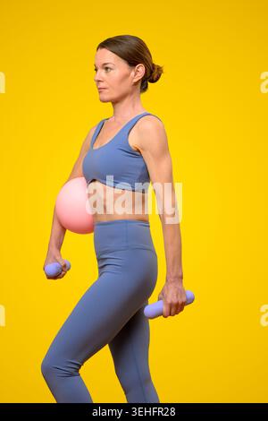 Frau, Die Mit Dumbells Und Übungsball Trainiert Stockfoto
