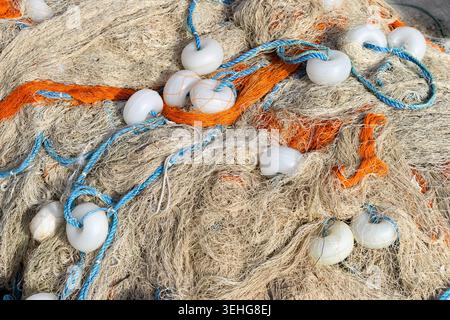 Nahaufnahme eines verwickelten Fischernetzes und einer Schwebelinie aus kommerziellen Fanggeräten Stockfoto