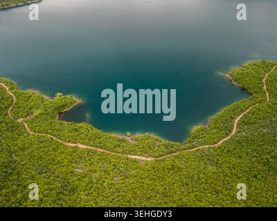 Slansko Lake, Montenegro - 05 29 2025: Drohnenfoto von oben nach unten vom Slansko Lake in Ponikvica, zeigt blaues Wasser, dichte Waldküste, gewundenen Pfad Stockfoto
