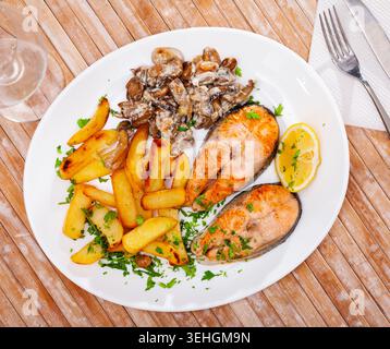 Lachs mit Kartoffeln und Pilzen ist ein leckeres Gericht in der Küche Stockfoto