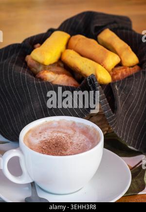 Traditionelle ecuadorianische Bizcochos mit Mini-Croissants und heißer Schokolade in gemütlicher Frühstücksumgebung Stockfoto