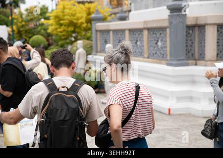 BANGKOK, THAILAND-16. MAI 2026: Seniorenpaar liest Reisekarte in der Hand, Reiseerlebnis im thailändischen Tempelkomplex, Rückansicht Stockfoto