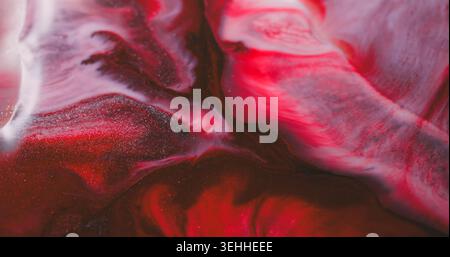 Tintenwelle. Stream Textur. Defokussierte rote lila rosa Farbe Glitzer Wasserspritzer, die auf abstraktem lebendigem Acrylhintergrund verbreitet sind. Stockfoto