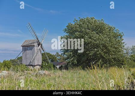 Traditionelle Holzwindmühle auf einem grasbewachsenen Feld, Ohessaare Windmühle auf der Insel Saaremaa bei sonnigem Sommerwetter, Estland, Europa. Stockfoto