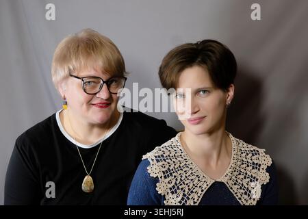 Porträt einer erwachsenen Tochter und Mutter auf grauem Ateliergrund. Stockfoto