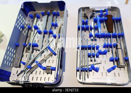 Orthopädisch-chirurgische Instrumente in sterilen Tabletts im modernen Operationssaal, medizinische Werkzeuge für Trauma- und Knochenchirurgie. Stockfoto