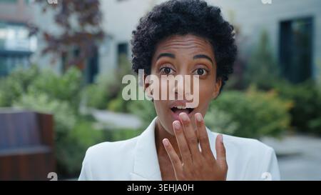 Afroamerikanische Geschäftsfrau staunte Öffnung Mund Abdeckung mit Hand erstaunliche Nachrichten Reaktion in der Stadt ethnische Geschäftsfrau weibliches Mädchen überrascht Stockfoto