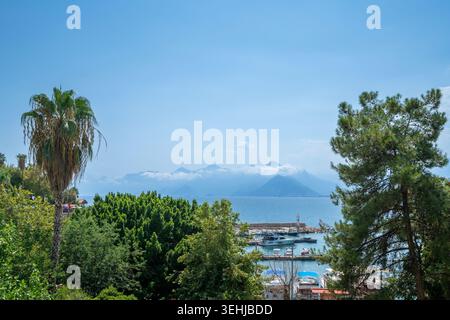 Malerischer alter Hafen von Antalya mit Blick auf den Leuchtturm und das Taurusgebirge auf das Mittelmeer, Türkei Stockfoto