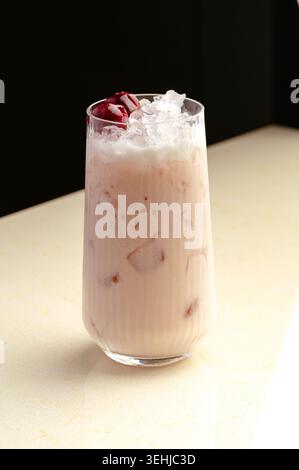 Milchshake mit Kirsche und Eis in einem Glas Stockfoto