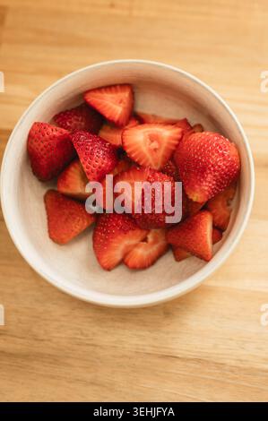 Blick von oben auf geschnittene frische Erdbeeren in einer Keramikschale Stockfoto
