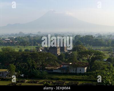 Aus der Vogelperspektive des Plaosan Lor Tempels und seiner zwei Steinschreine mit dem Berg Merapi im Hintergrund in Kecamatan Prambanan, Jawa Tengah, Indonesien. Stockfoto