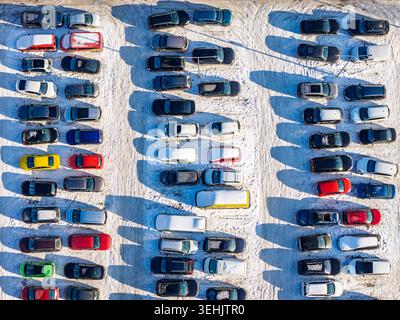 Aus der Vogelperspektive auf einem schneebedeckten Parkplatz mit langen Schatten auf dem Boden im Winter in Warschau, Masowischer Woivo Stockfoto
