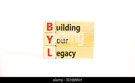 BYL baut Ihr altes Symbol auf. Concept Words BYL baut Ihr Vermächtnis auf wunderschönen Holzblöcken auf. Schöner weißer Hintergrund. Business BYL Gebäude Stockfoto