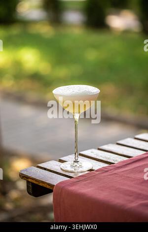 Schaumiger Cocktail auf Holztisch im Freien Stockfoto