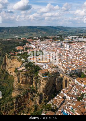Aus der Vogelperspektive auf die historische Stadt mit der Puente Nuevo Brücke, der Plaza de Toros de Ronda und weißen Häusern auf steilen Klippen Ronda, Andal Stockfoto