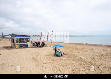 Menschen am Sandstrand an einem heißen, sonnigen Frühlingstag im Mai in der Küstenstadt Weymouth an der englischen Südküste. Stockfoto