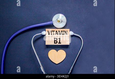 Vitamin B1-Symbol. Concept Words Vitamin B1 auf schönen Holzblöcken. Holzherz und Stethoskop. Schöner schwarzer Hintergrund. Medizinisch gesundes Leben Stockfoto