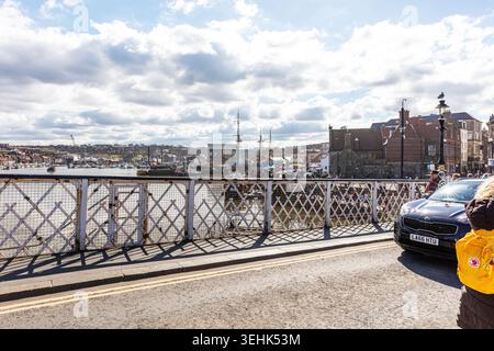 Ein Blick von der Brücke in Whitby, North Yorkshire, mit dem Metallgittergeländer, einem geparkten Auto und einer Person, die daneben steht. Im Hintergrund Stockfoto